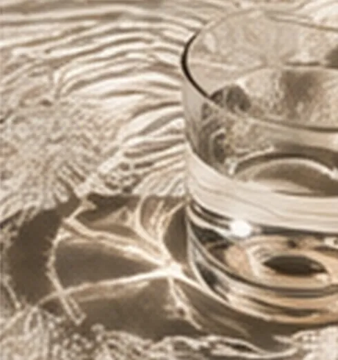 Light refracted through a glass of water onto a table